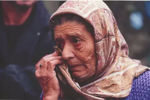 Paul GROVER - Fotografie - An elderly Bosnian Muslim woman wipes away a tear